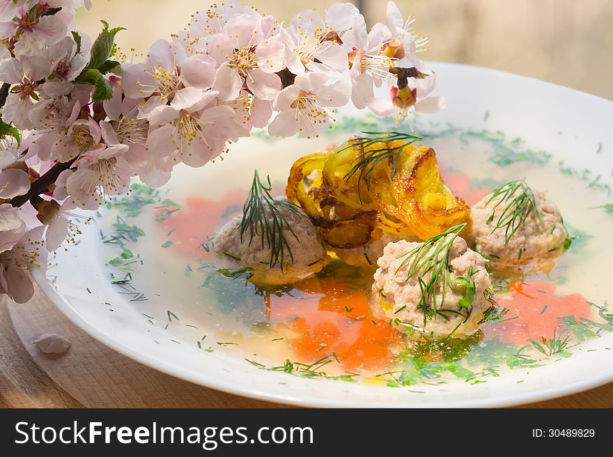 Soup with meatballs and blossoming branch apricots