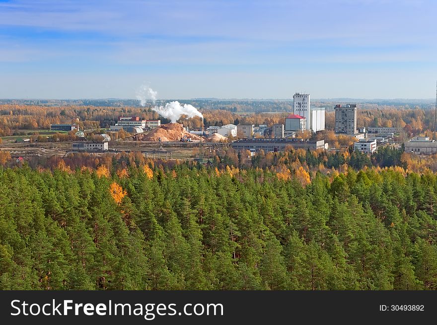 Factory in a green forest polluting the environment