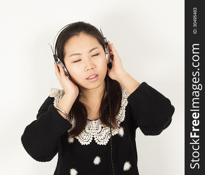 Young woman listening to music with headphones. Young woman listening to music with headphones.