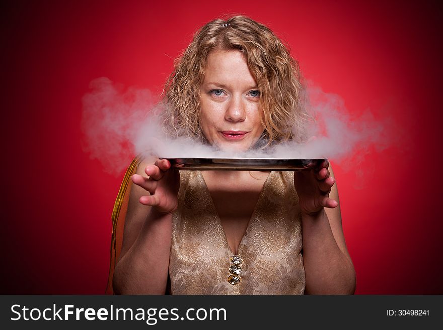 Blonde woman on red background show magic with smoke. Blonde woman on red background show magic with smoke