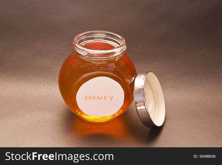 Pure honey in open bottle.