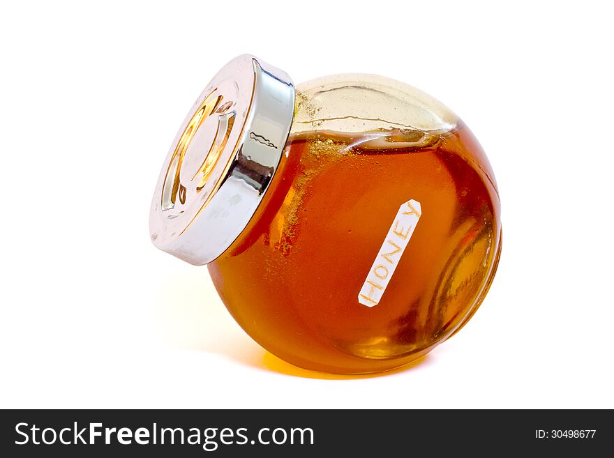 Glass jar of honey on white, with clipping path.