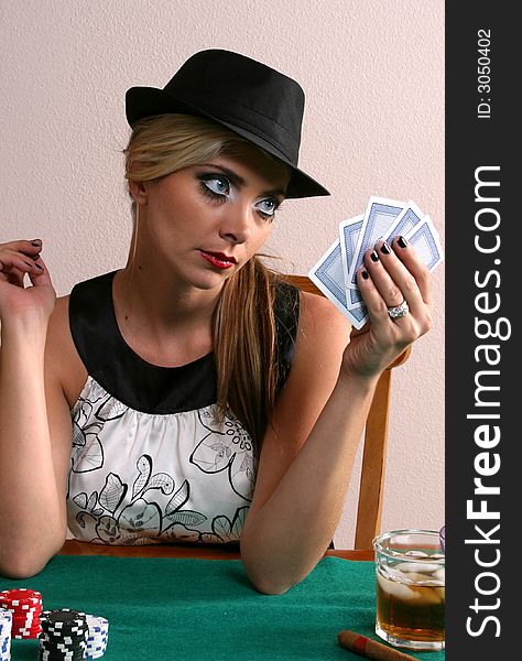 Beautiful woman with cards in hand and chips on table. Beautiful woman with cards in hand and chips on table.