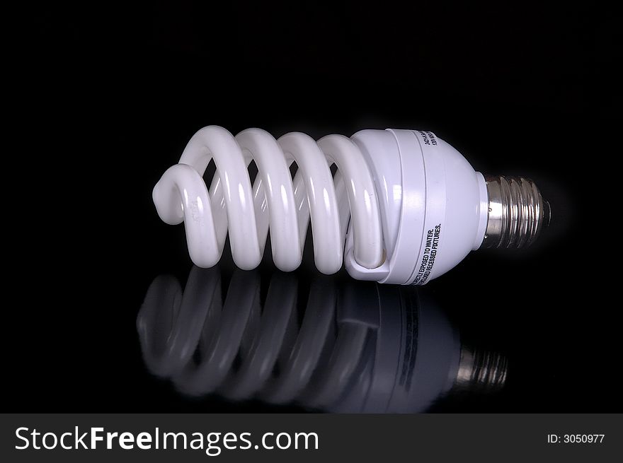 A fluorescent light bulb against a black background.