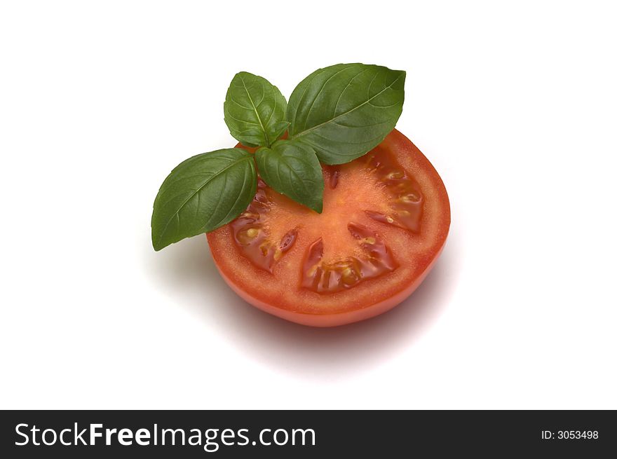 Healthy fresh tomato with green basil leaf isolated on white