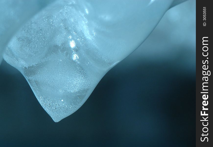 Melting icicle, a few seconds before its frozen peak is to turn into drop of water. Melting icicle, a few seconds before its frozen peak is to turn into drop of water.