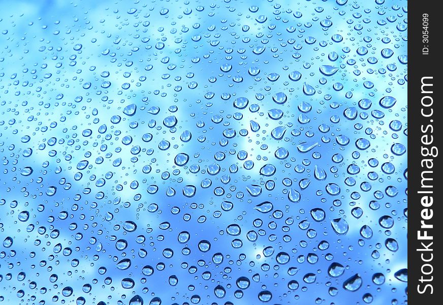 Water drops on glass against the sky