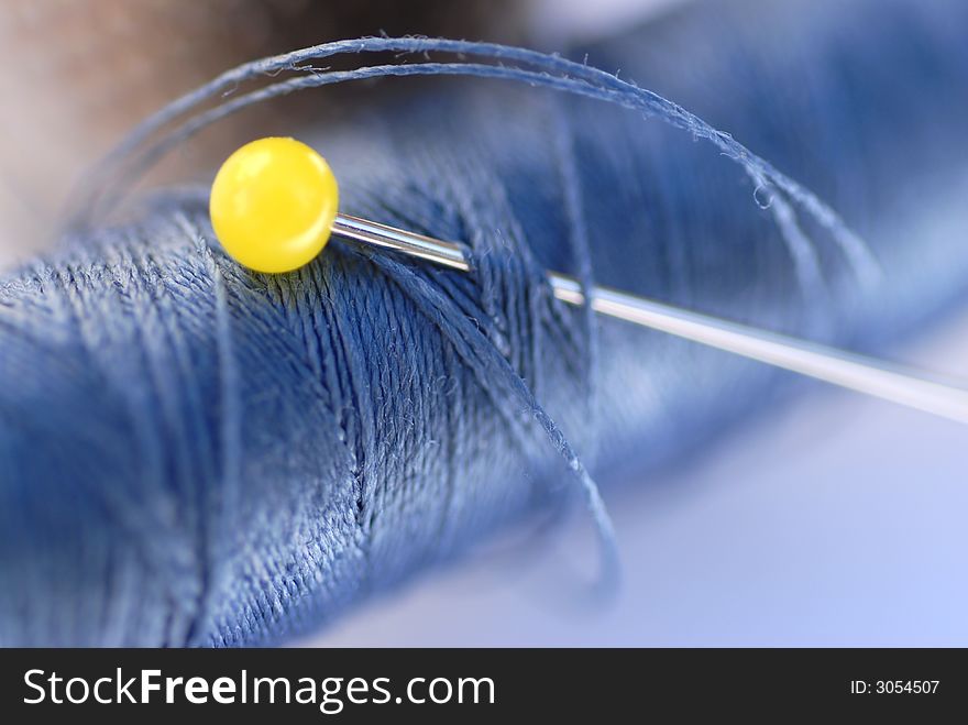 Blue thread and yellow pin close up