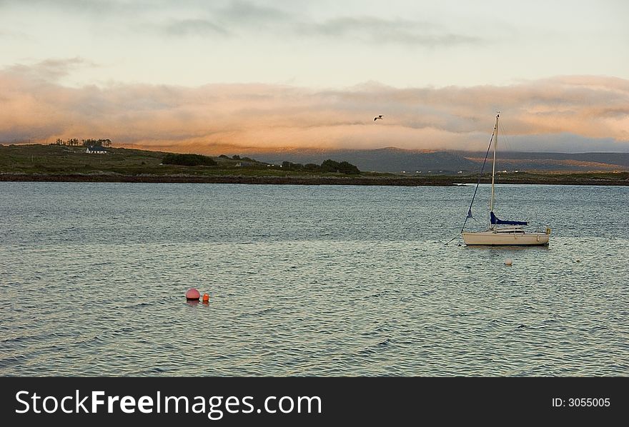 Sailing boat at Roundstone (Ireland) at sunset