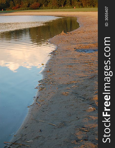 The edge between water and sand during sunset. The edge between water and sand during sunset