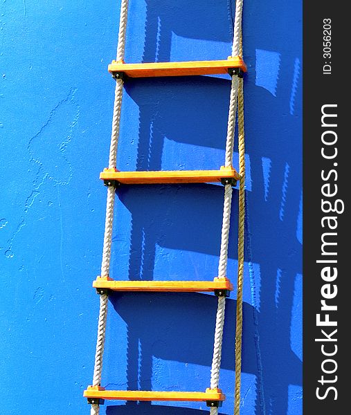 Shot of a latter hanging of the side of a blue boat. Shot of a latter hanging of the side of a blue boat.