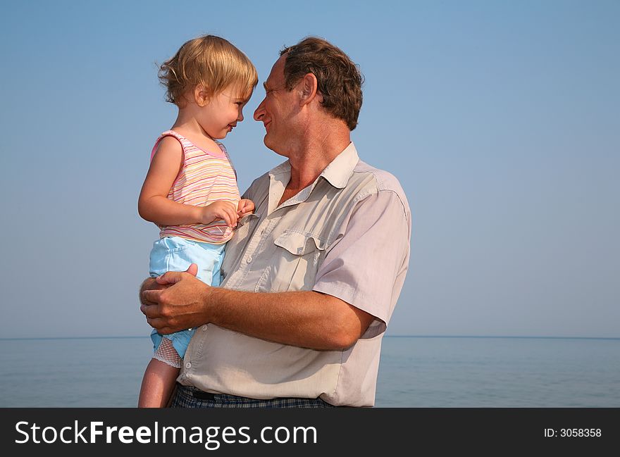 Grandfather holds granddaughter on hands. Grandfather holds granddaughter on hands