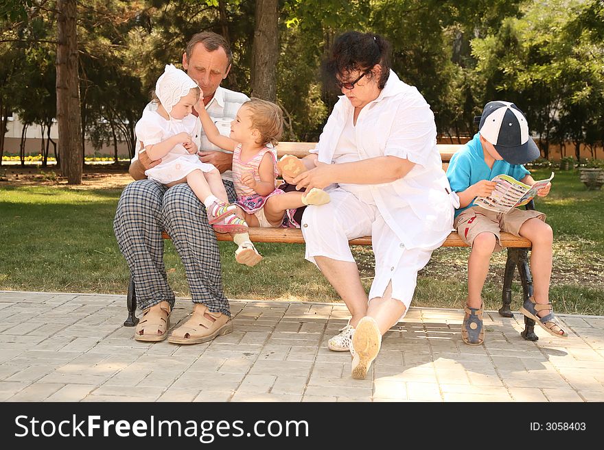 Grandmother with grandfather seat with grandchild on bench. Grandmother with grandfather seat with grandchild on bench