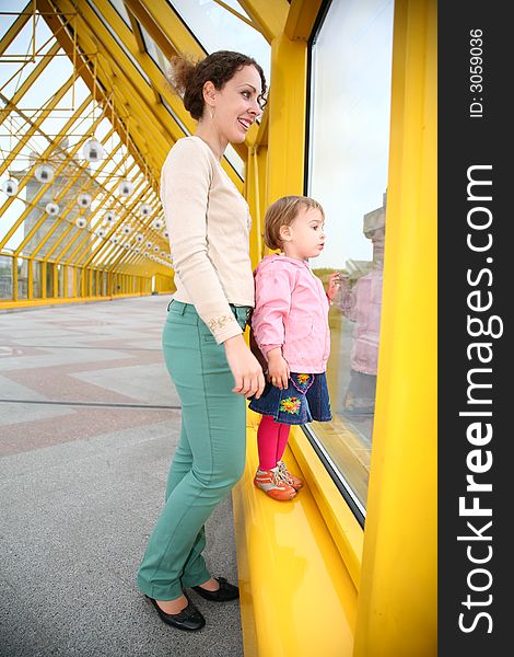 Young woman with baby on pedestrain bridge