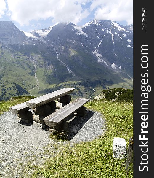 Small wooden bench on GroÃŸglocknerstraÃŸe in Alps mountians in Austria. Small wooden bench on GroÃŸglocknerstraÃŸe in Alps mountians in Austria