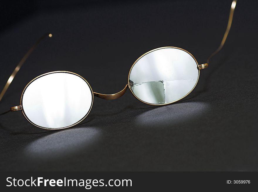 Pair of antique gold-rimmed spectacles, one lens cracked. Pair of antique gold-rimmed spectacles, one lens cracked.