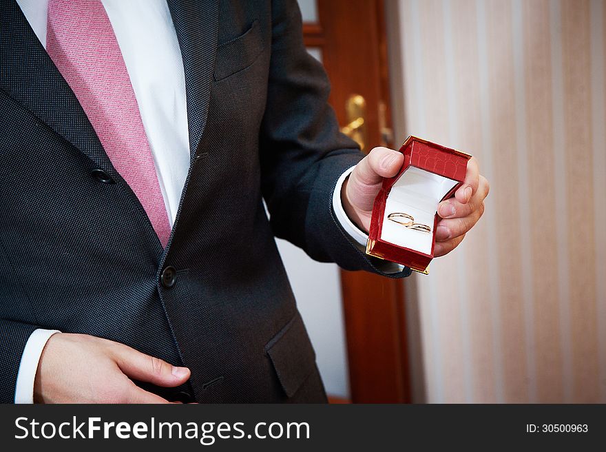 Groom holds a box with wedding rings. Groom holds a box with wedding rings