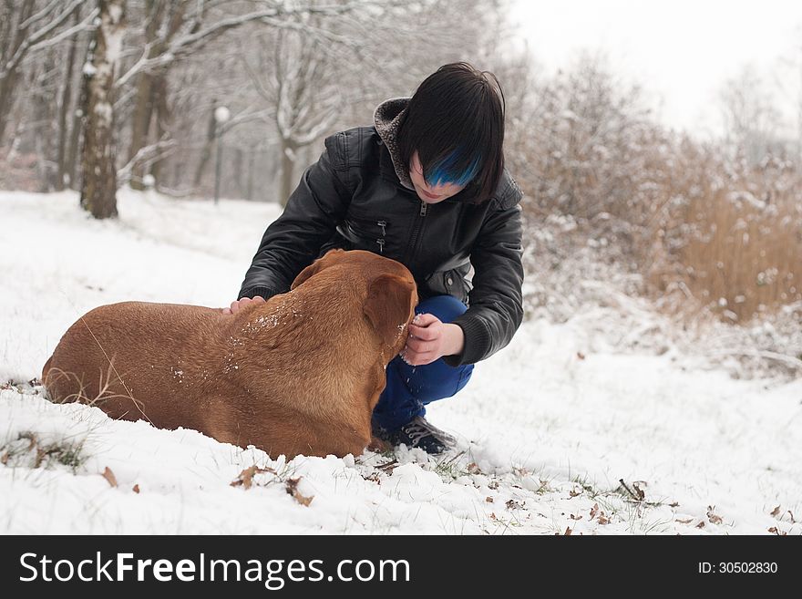 Funky boy is having fun with his dog in the snow. Funky boy is having fun with his dog in the snow