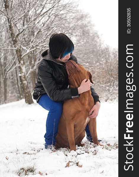 Funky boy is having fun with his dog in the snow. Funky boy is having fun with his dog in the snow