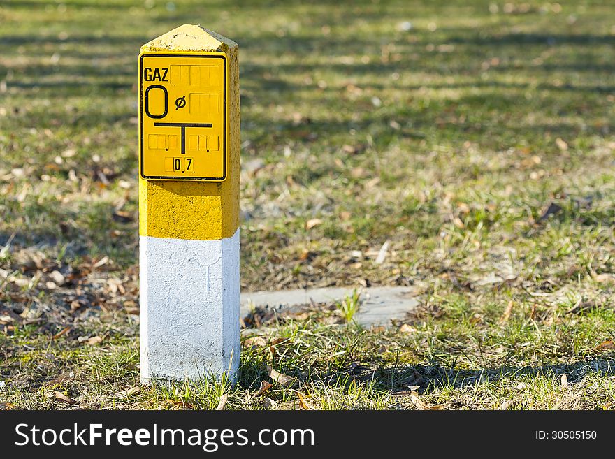 Yellow pole indicative of natural gas made â€‹â€‹of concrete with a sign. Yellow pole indicative of natural gas made â€‹â€‹of concrete with a sign