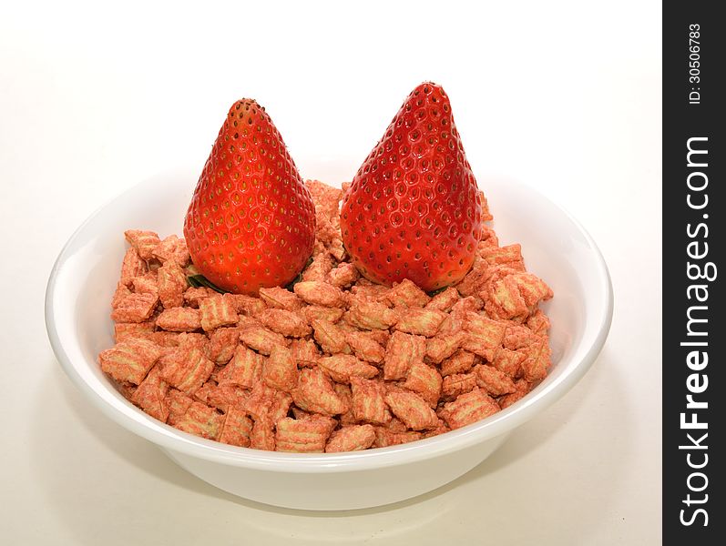 Two strawberries on a bowl of cereal. Two strawberries on a bowl of cereal.