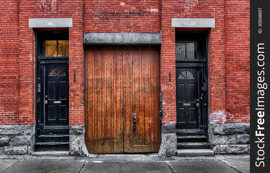 Very rustic old wooden black and natural doors & brick wall. Very rustic old wooden black and natural doors & brick wall