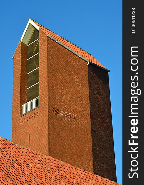 Red tiled roof and the bell tower in red bricks of a modern church - Aarhus, Denmark. Red tiled roof and the bell tower in red bricks of a modern church - Aarhus, Denmark