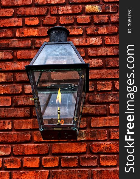 Old gaslight lantern close up on a red brick wall. Old gaslight lantern close up on a red brick wall
