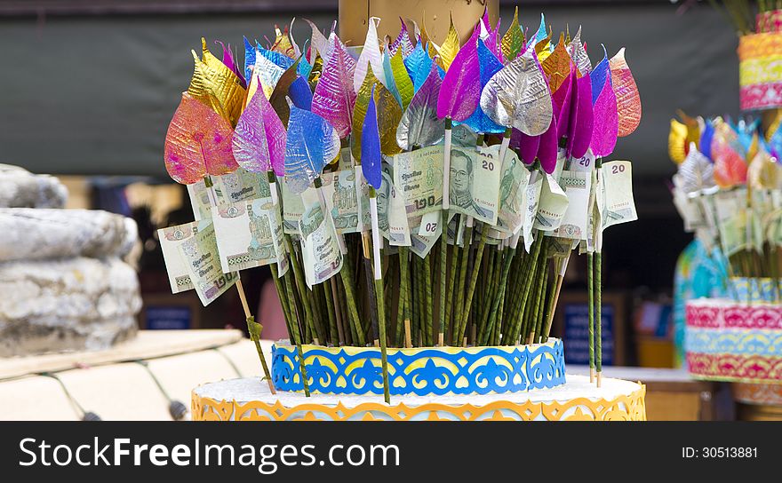 Money for making merit attached with colorful Bothi leaves