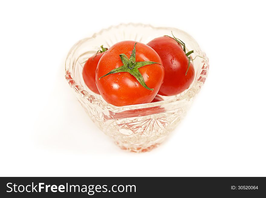 Juicy and ripe tomatoes in a glass vase