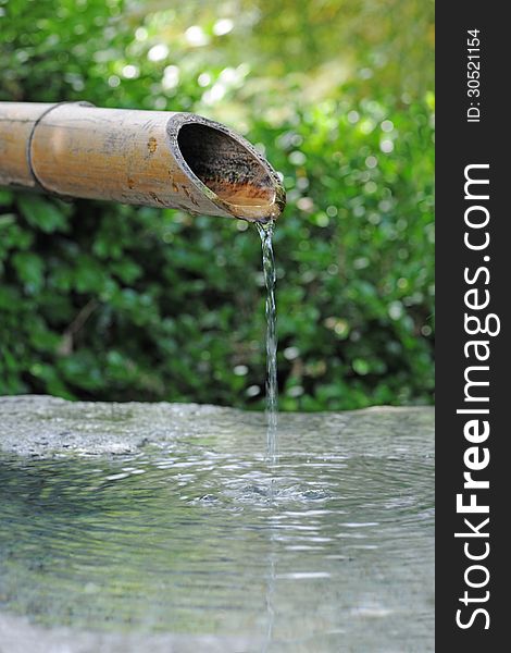 Japanese bamboo fountain with water dripping from snout