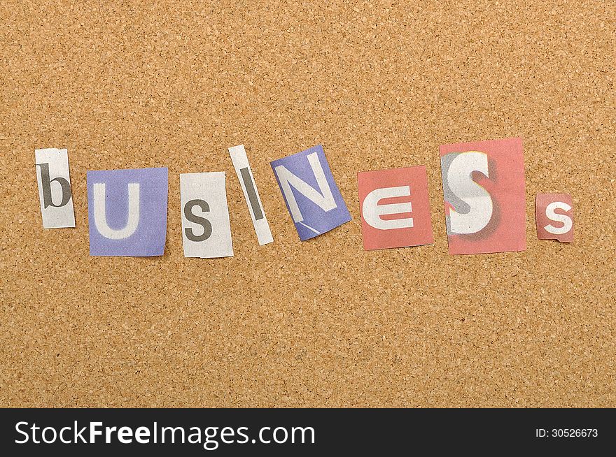 Business word made from newspaper letter shot over pinboard background