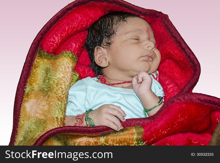 New born baby sleeping on red blanket and isolated on light pink background