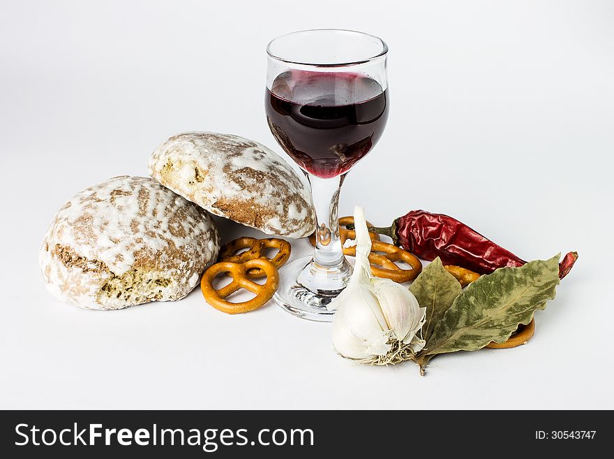 Wine and spicy flavor, homemade bread and green leaves on white background.