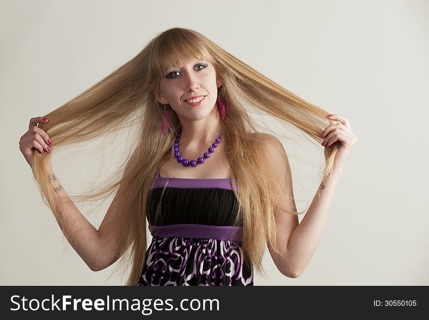 Portrait of a pretty young girl with long hair posing in studio on light background. Portrait of a pretty young girl with long hair posing in studio on light background