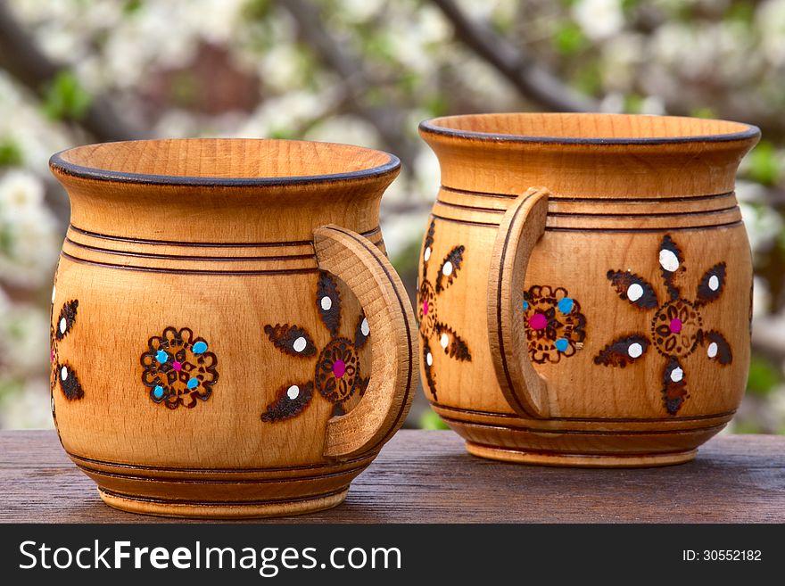 Two wooden mugs with an ornament on a soft background