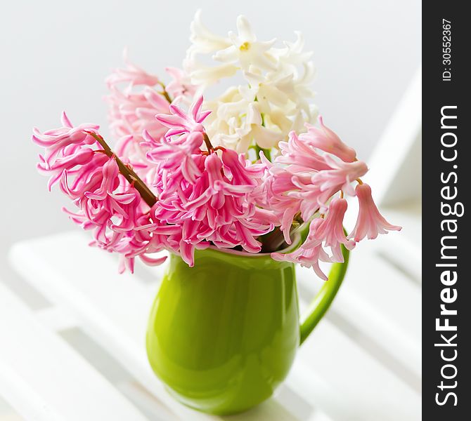 Still life with spring pink and white flowers in a bright green pot. Still life with spring pink and white flowers in a bright green pot