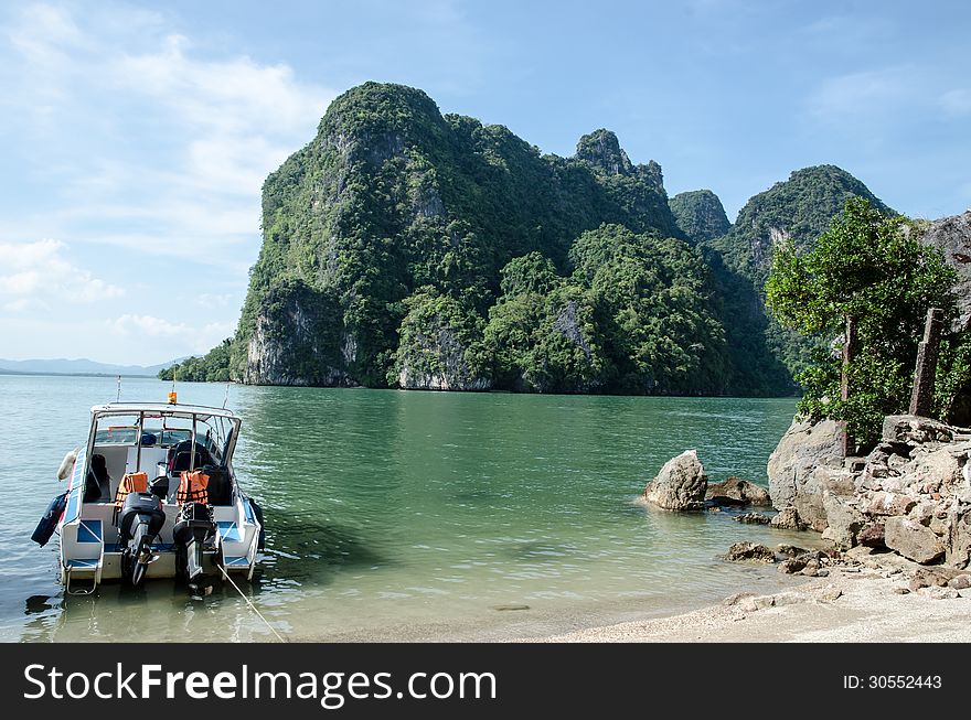 Tropical Island in Thailand with a speedboat