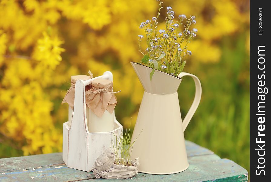 On a yellow background with a jug of wild flowers and bottles. On a yellow background with a jug of wild flowers and bottles