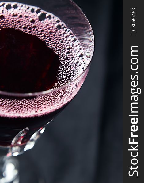 Red wine in wineglass on a black background