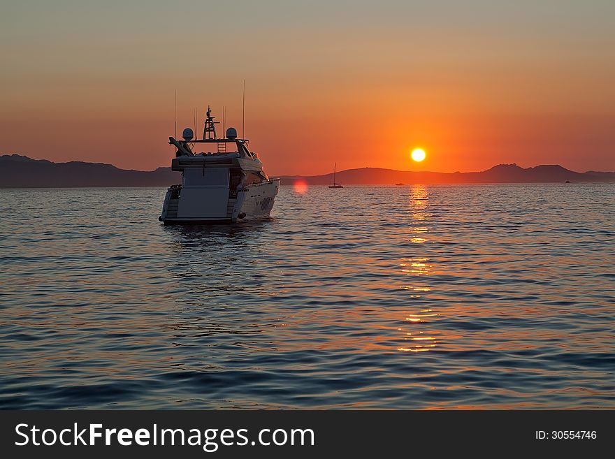 Private motor yachts rest in the bay at sunset