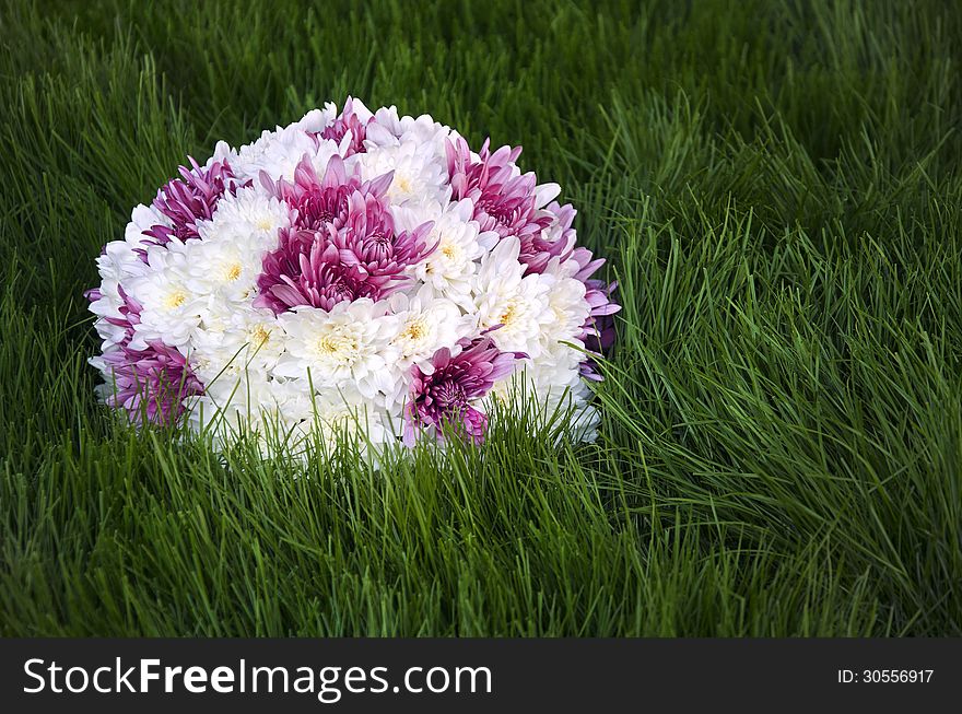 White an purple flowers ball on fresh grass