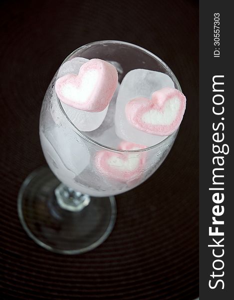 Pink heart marshmallow frozen in ice cube. Pink heart marshmallow frozen in ice cube