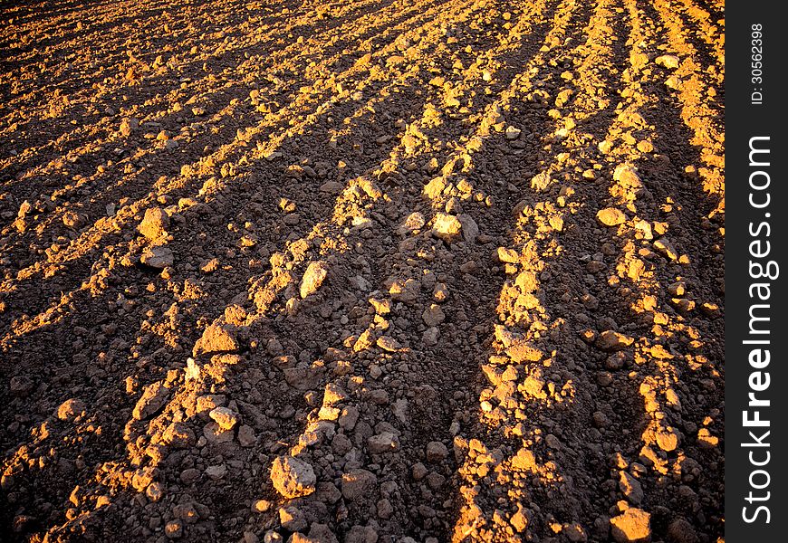 Black ploughed field Illuminated sunrays in springtime. Black ploughed field Illuminated sunrays in springtime.