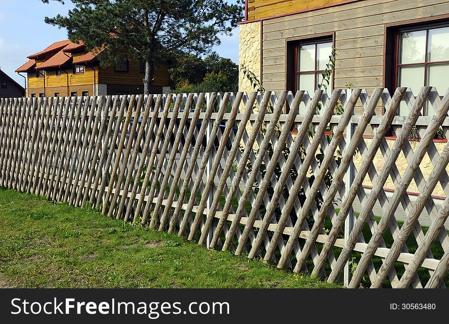 Wooden village house behind the fence. Wooden village house behind the fence