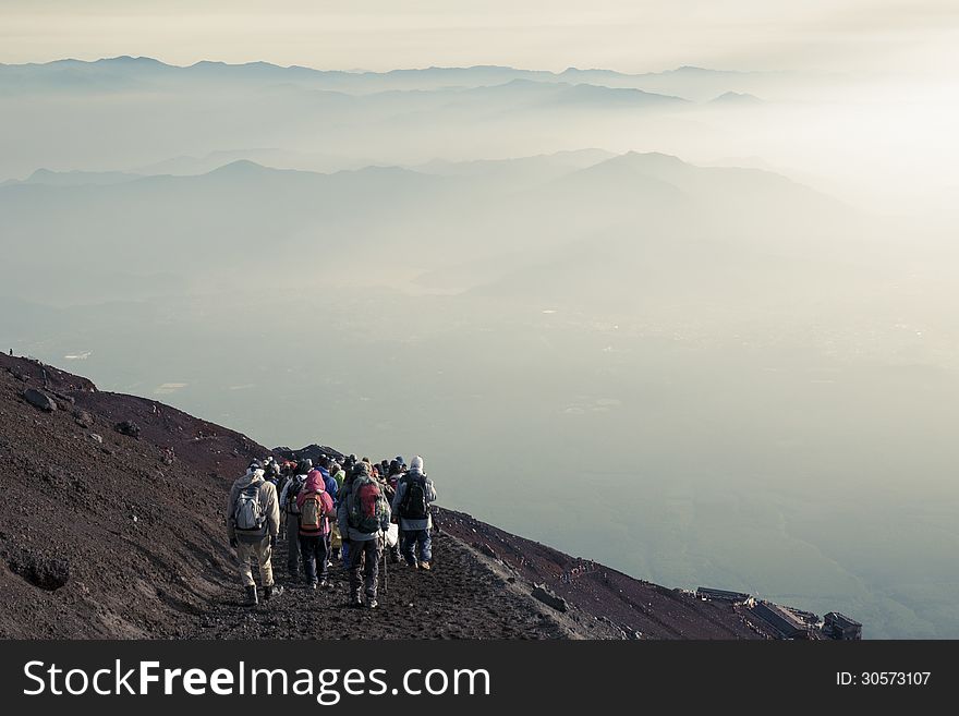 Unidentified tourists go down from Mt.Fuji summit in haze morning atmosphere. Unidentified tourists go down from Mt.Fuji summit in haze morning atmosphere