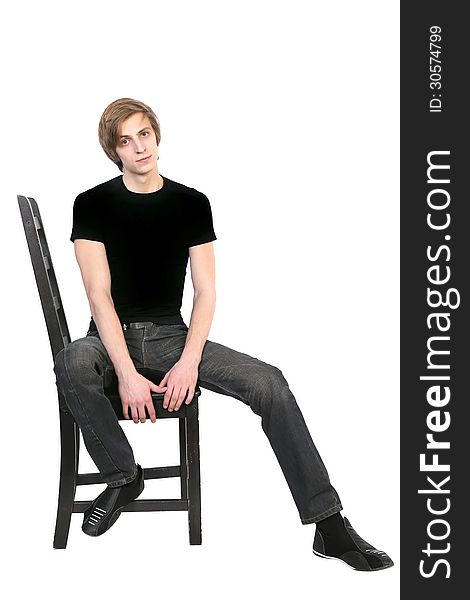 Handsome young man in black clothes sitting on a chair on white background. Handsome young man in black clothes sitting on a chair on white background