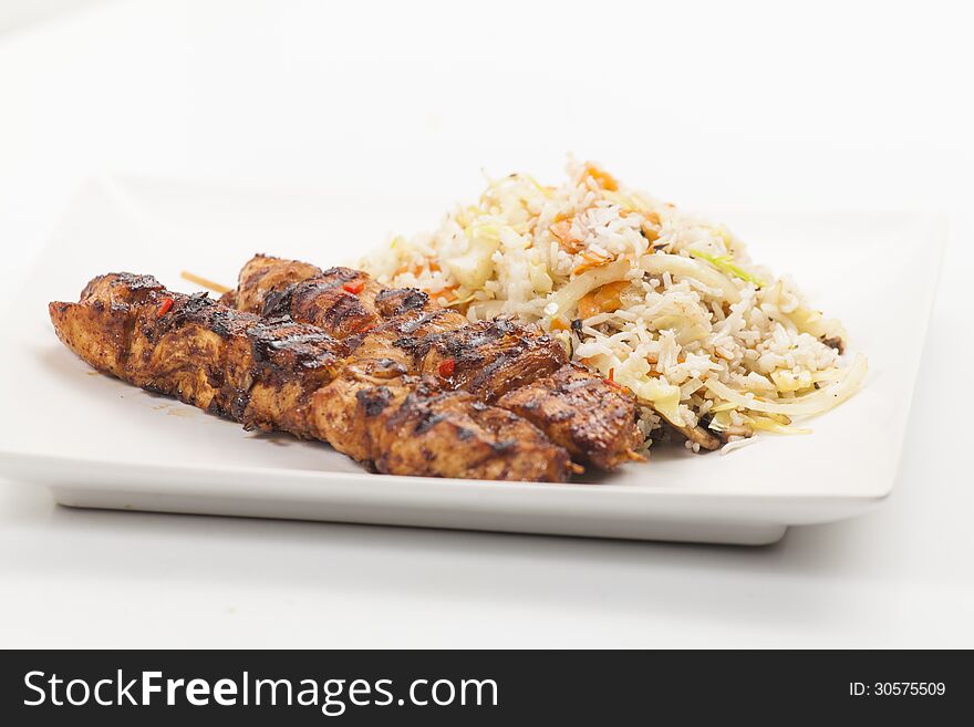 Chicken skewers serve with vegetable rice. Chicken skewers serve with vegetable rice