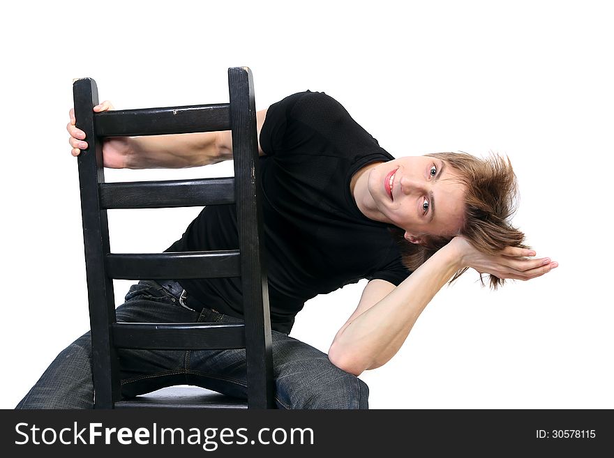 Handsome young man playing a fool sitting on a chair on white background. Handsome young man playing a fool sitting on a chair on white background