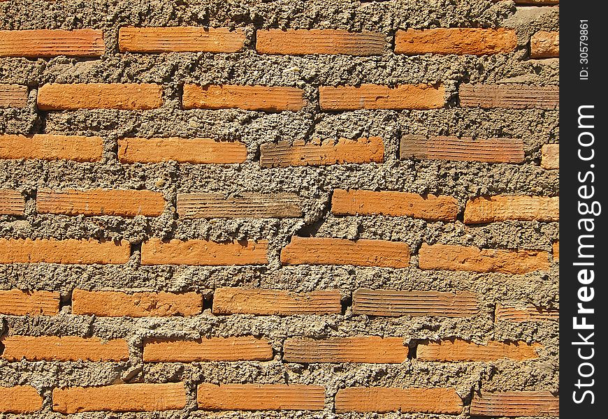 Pattern of brick and concrete wall in sunlight